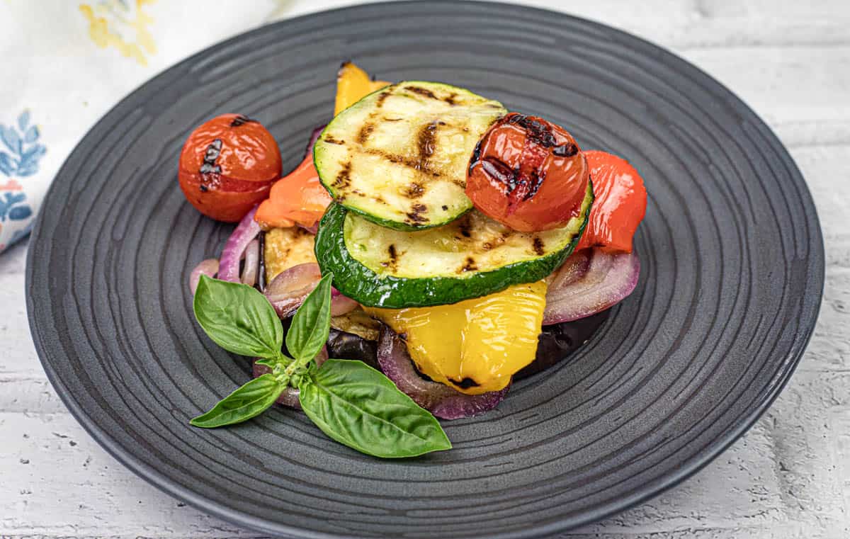 Close-up shot of Grilled Ratatouille on a black plate.