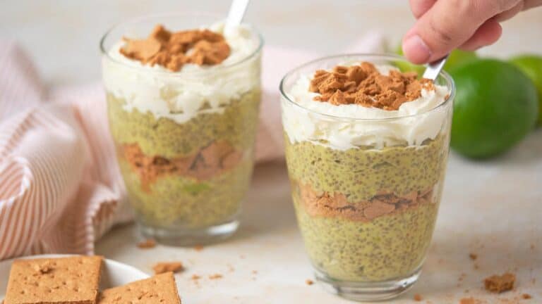 Two glasses of chia seed pudding layered with crushed graham crackers and topped with whipped cream.