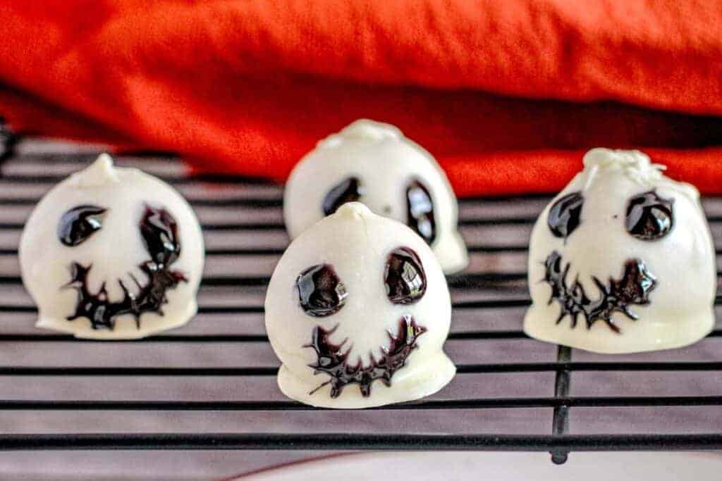 Four pieces of Skeleton Oreo Cookie Balls on a rack.